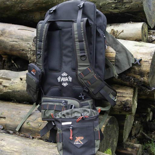 Black tactical backpack on a pile of logs with visible branding.